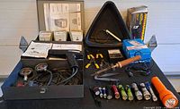 overview of open metal cases with automotive diagnostic tools and assorted flashlights