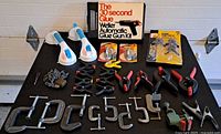 All items arranged on table showing variety of clamps, lifters, glue gun kit and accessories