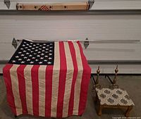 Flag draped, pole above, andirons and stool visible