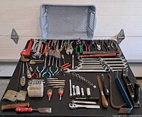Full view of lot on black surface showing variety of tools and blue tote