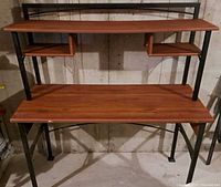 Full view of wood-grain desk with metal frame, showing main surface, top shelf, and cubbies