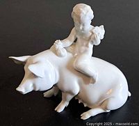 Side view of cherub riding pig
