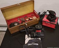 Overview showing both Craftsman sanders, wooden toolbox and attachments