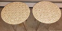 Two matching round tile-top tables side by side
