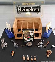 Group shot of entire lot including sign, crate, horses, stoppers, chariot with stirrers and bar tools