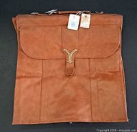 Full front view of brown garment bag with tags attached