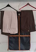 Garment bag hanging open displaying two pants on hangers