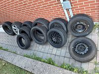 All 11 tires and wheels lined against wall
