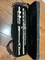 Flute disassembled into headjoint, body, foot joint inside velvet-lined case