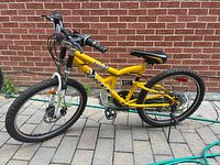 Side view of yellow Oryx Energy 24" mountain bike with full suspension