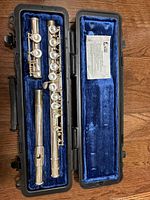 Open case displaying three flute sections and blue lining
