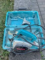 Makita corded hand planer inside teal carrying case with metal fence guide