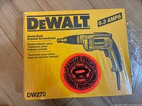Front of sealed DeWalt DW272 drywall screwdriver box showing branding, amperage and model