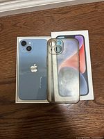 Rear of blue iPhone 14, clear case and retail box visible