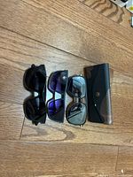 Overview of two sunglasses and case on floor