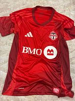 Front view showing Adidas logo, Toronto FC crest, BMO sponsor, Global Toronto Area patch