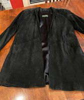 Front view of black suede jacket laid flat showing overall design and length