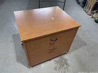 Front and top view of IKEA two-drawer file cabinet showing handles, finish and casters