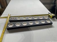 Two black Ikea tealight holders each containing six tealights on measuring surface showing ~60 cm length