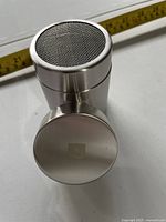 Front view of stainless steel Nespresso shaker showing mesh top and logo base