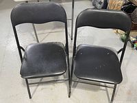 Front view showing two black metal folding chairs