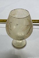 Full view of goblet-style tea light holder with tape measure in background
