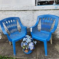 full view of both plastic chairs and flower basket