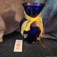 Front view of cobalt blue vase with yellow ribbon and lot tag 59
