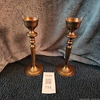 both brass candlesticks standing side by side