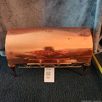 Front view of closed copper domed chafing dish on stand