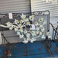 Full view of dogwood wall plaque on metal bench