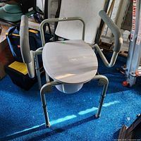 Overall view of commode with arms raised showing frame and legs