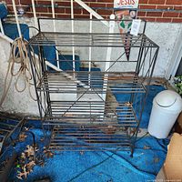 Full view of black metal folding rack with four shelves