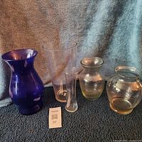 Five assorted glass vases standing together