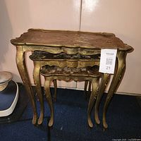 Three stacked gold nesting tables front view