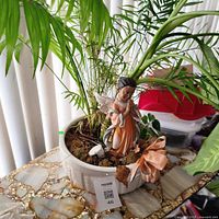 Planter with live plant and angel figurine on tabletop