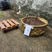 Planter bowl with soil and wooden wheeled caddy side by side