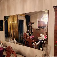 Full view of large frameless mirror mounted on wall