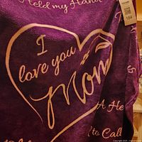 Front of purple throw showing heart motif and main phrase