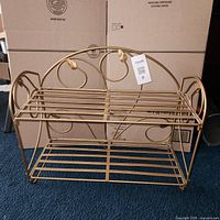 Full view of gold metal foldable rack with two shelves
