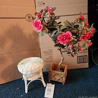 Wicker stool and faux rose bush side by side