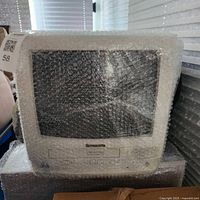 Front view of Panasonic CRT TV/VCR combo wrapped in bubble wrap
