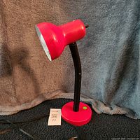 Full view of red desk lamp showing shade, neck, base and cord