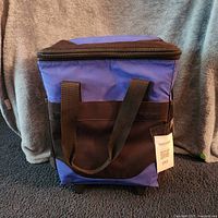 Front view of blue and black rolling cooler