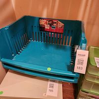 Two teal plastic stacking bins nested, showing overall design