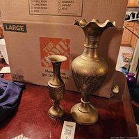 Overview of both brass vases on tabletop