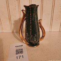 Full view of green vase with gold handles