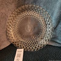 Full view of clear pressed glass platter on fabric backdrop