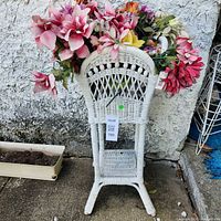 full view of wicker stand with faux flowers