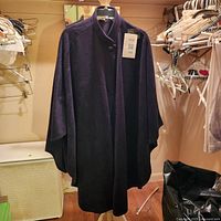 Full front view of dark purple cape on hanger